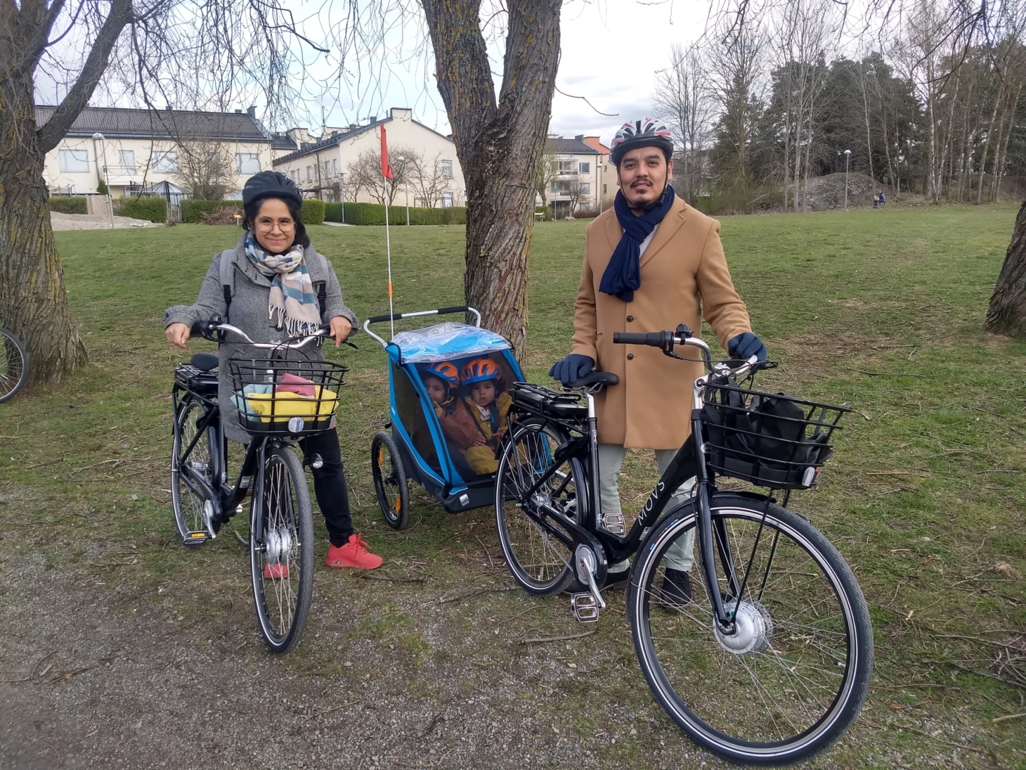 Ninel och Mickey med sina elcyklar och barnen i en cykelkärra