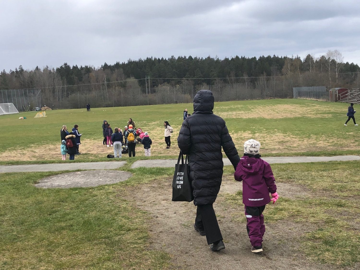 En mamma kommer gående med sin dotter till träningen