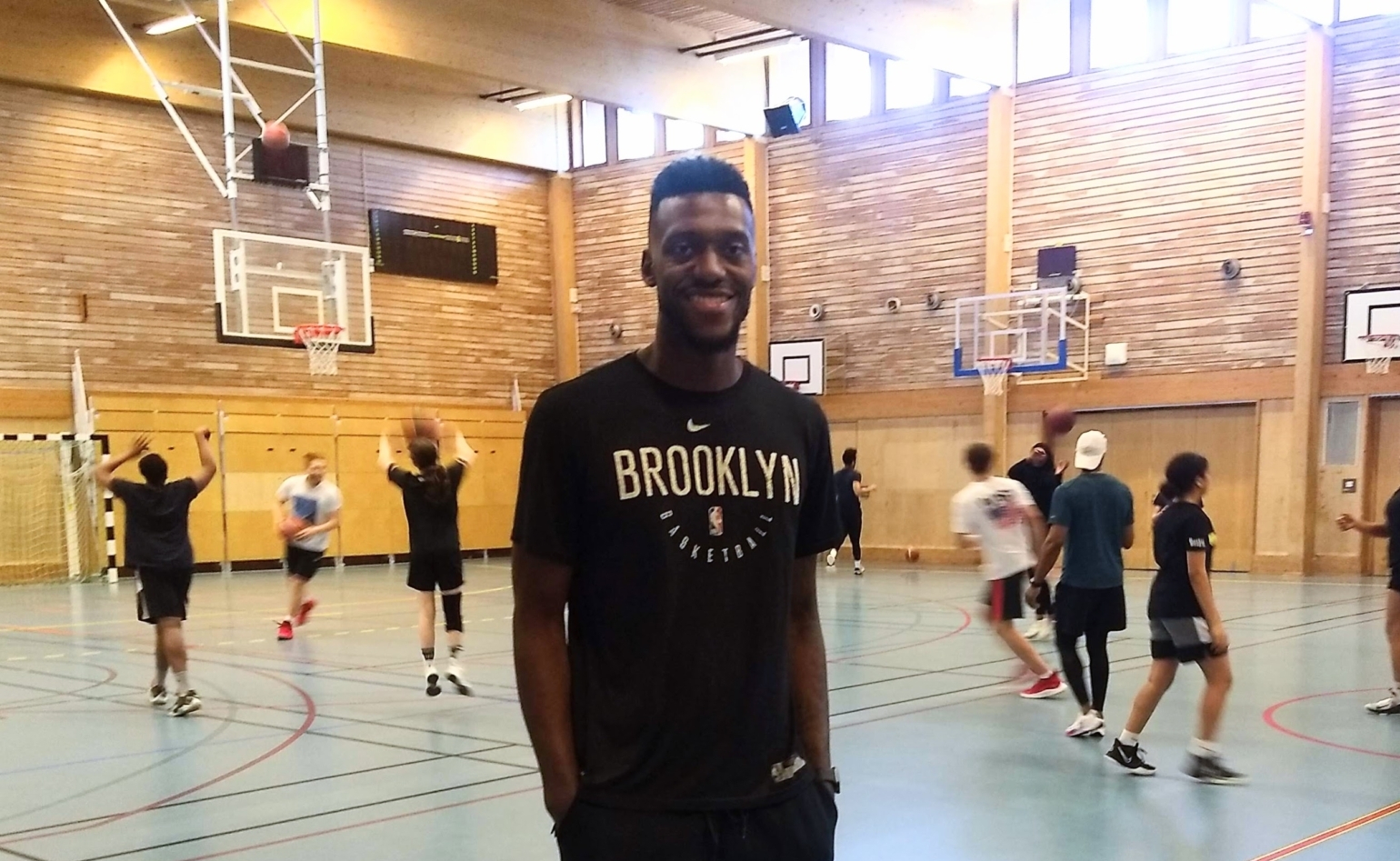 Mike Moore med basketspelande ungdomar i bakgrunden