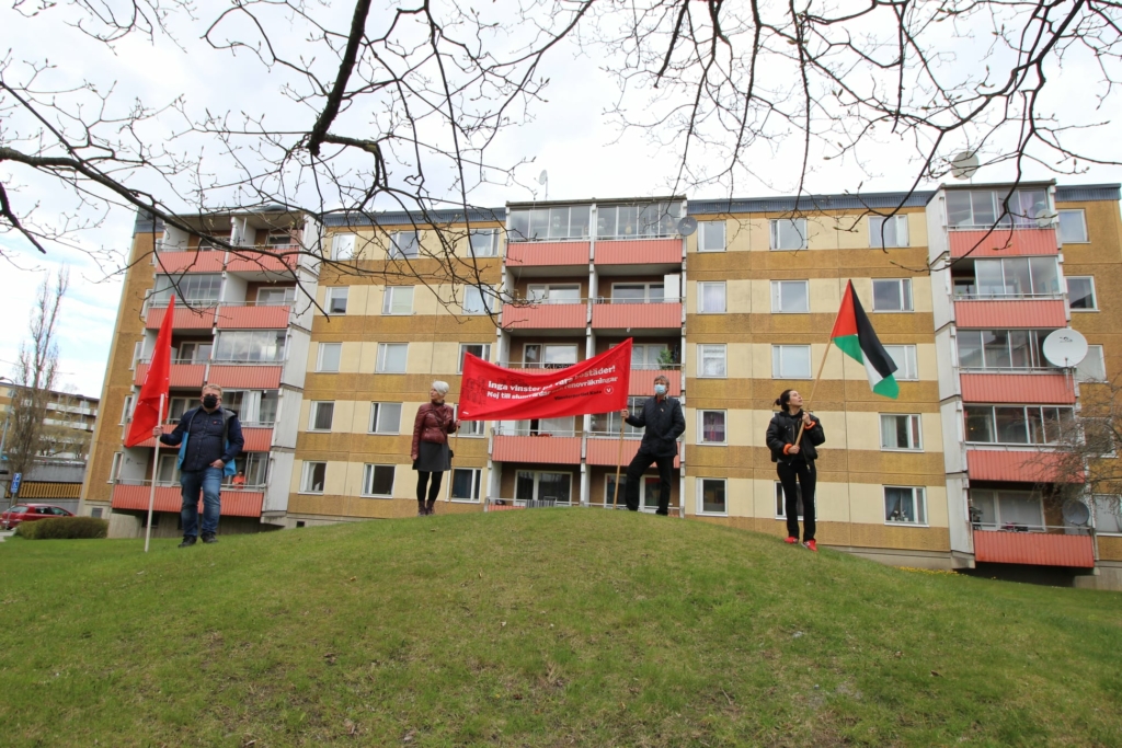 vänsterpartister med en röd banderoll och palestinaflagga