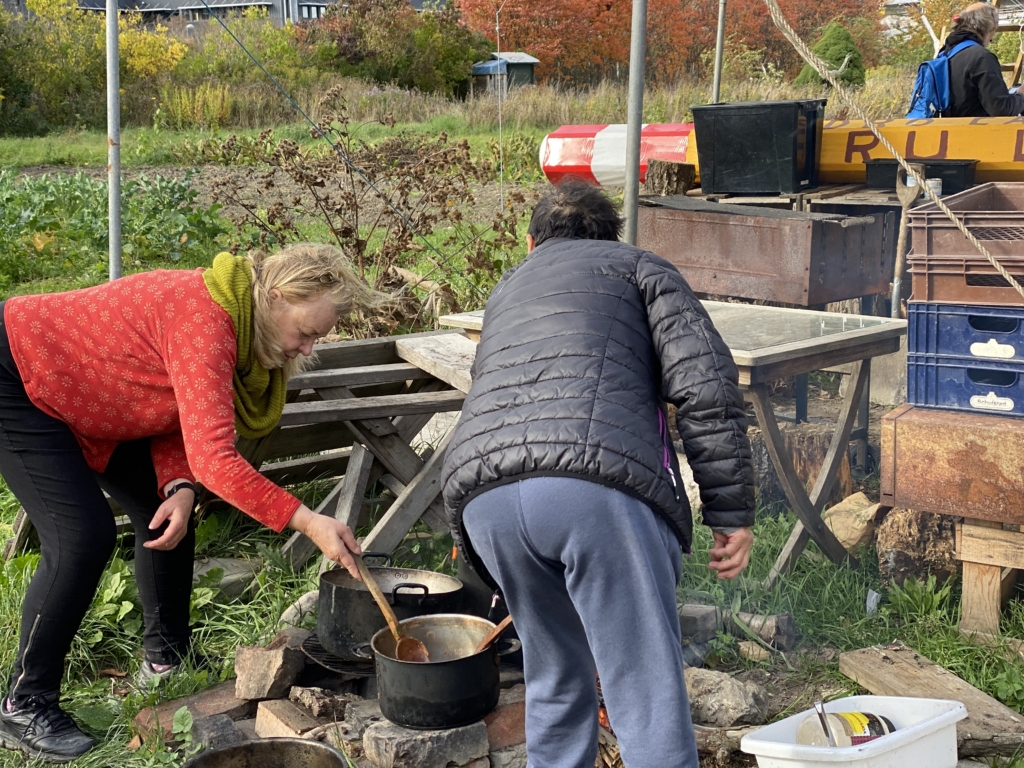 Två kvinnor lagar mat utomhus