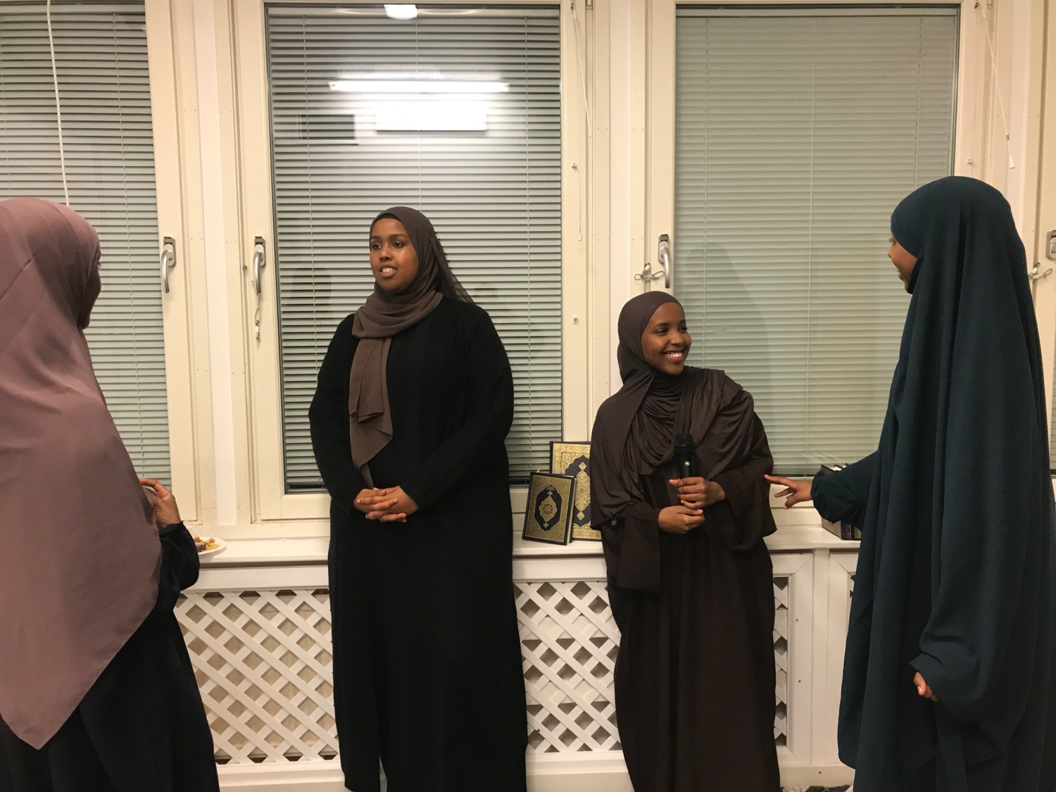 Fyra hijabis pratar och ler