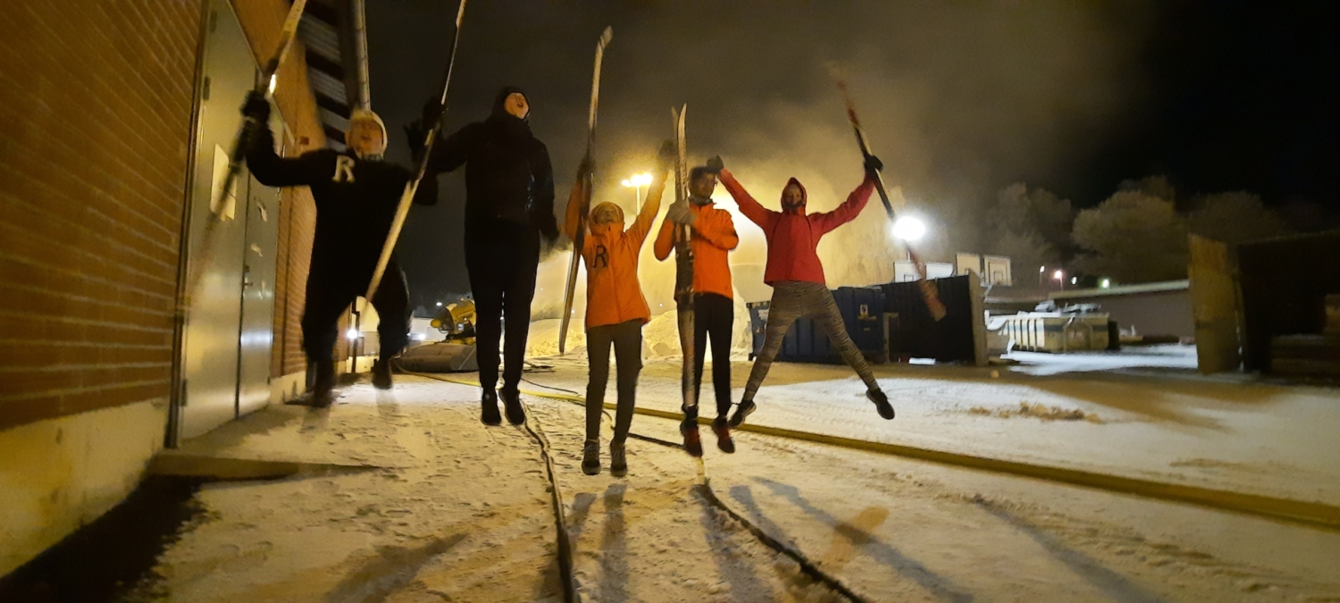 Fem personer som hoppar upp i luften med skidorna på.