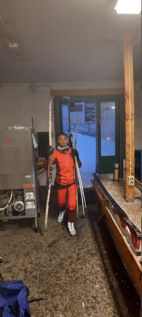 person i orange träningskläder bär skidor