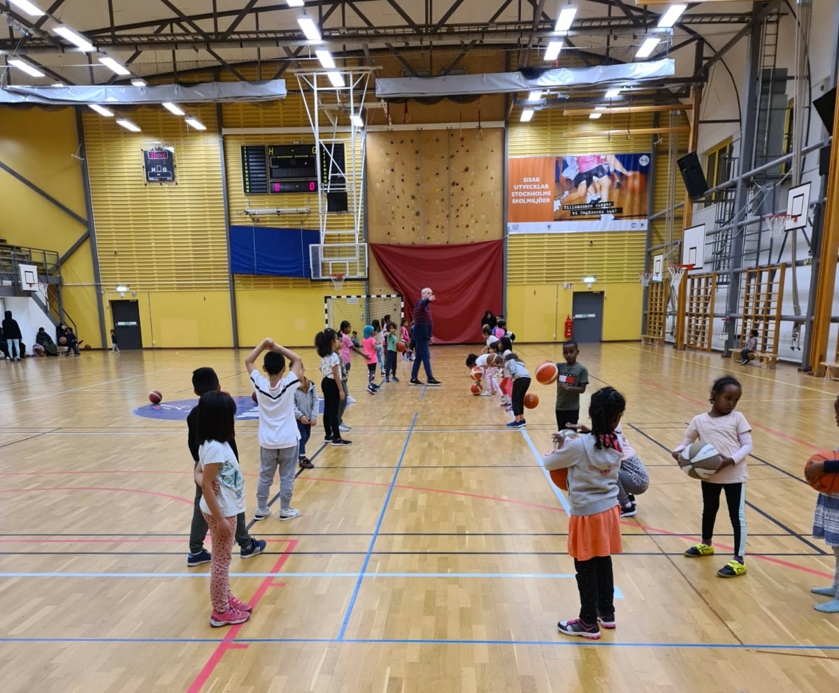 Barn som spelar basket.