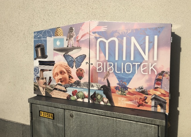 Minibibliotek ovanpå ett elskåp.