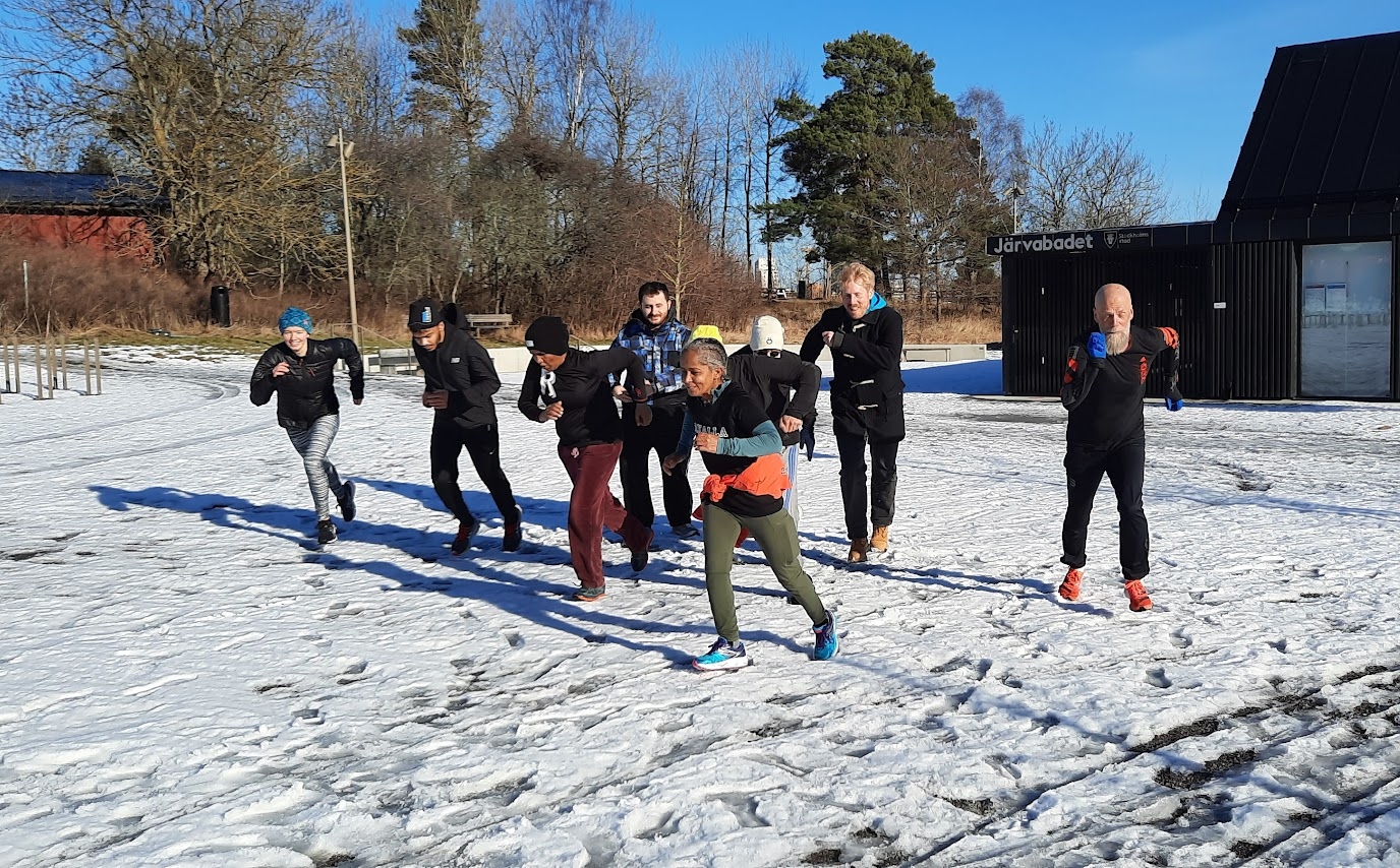 En grupp som springer över ett snötäckt fält.