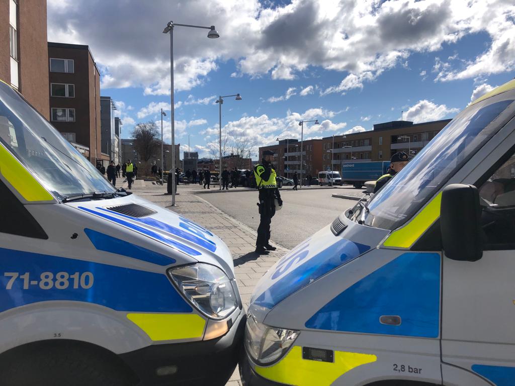 Polisbilar parkerade med fronten mot varandra i gatumiljö