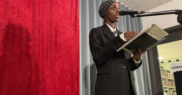 ung kvinna med sidenscarf om håret läser dikt i mikrofon