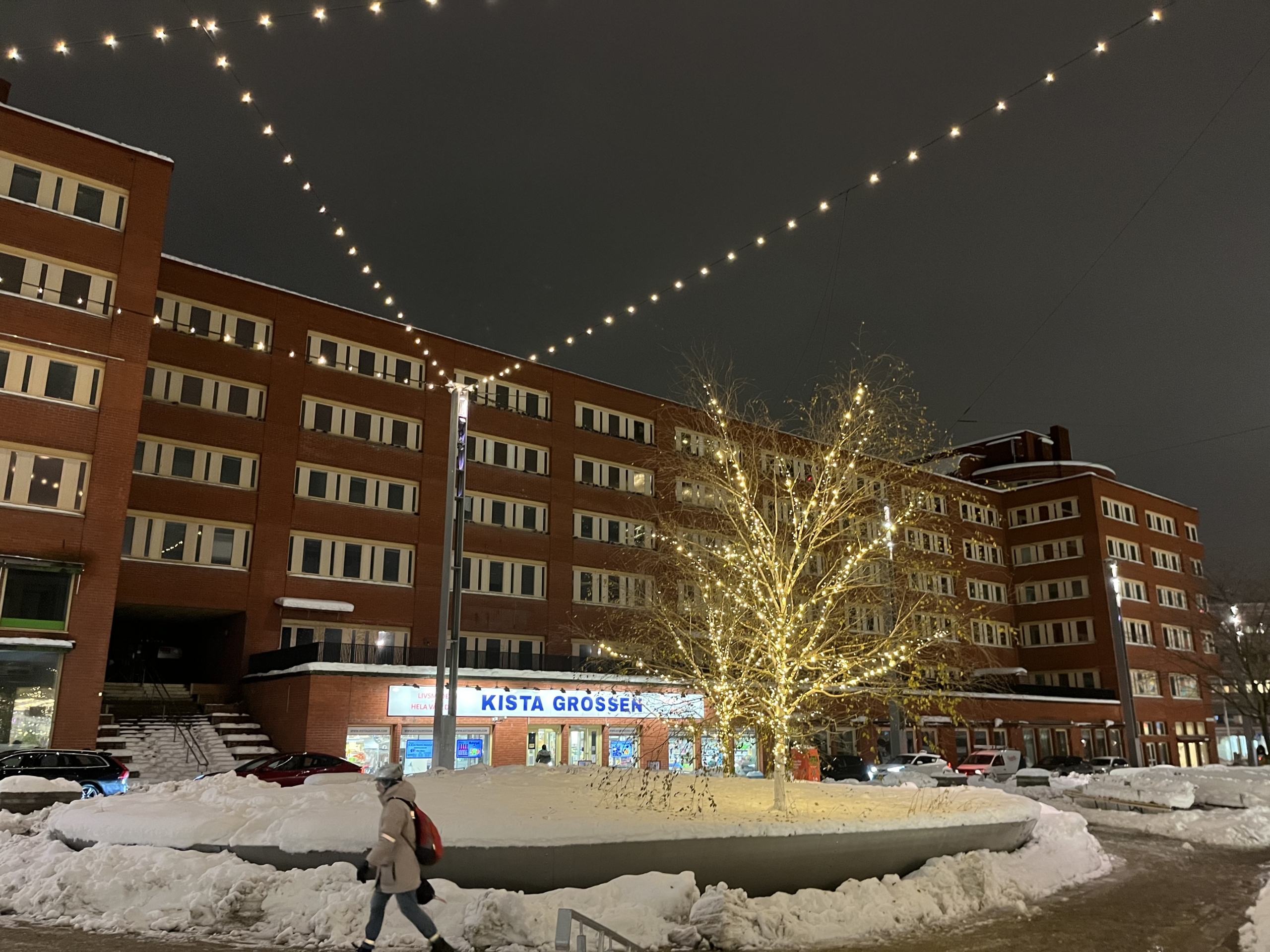 snöigt torg med ljusslingor i träd