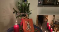Bok står på ett bord med en liten julgran och ett ljus
