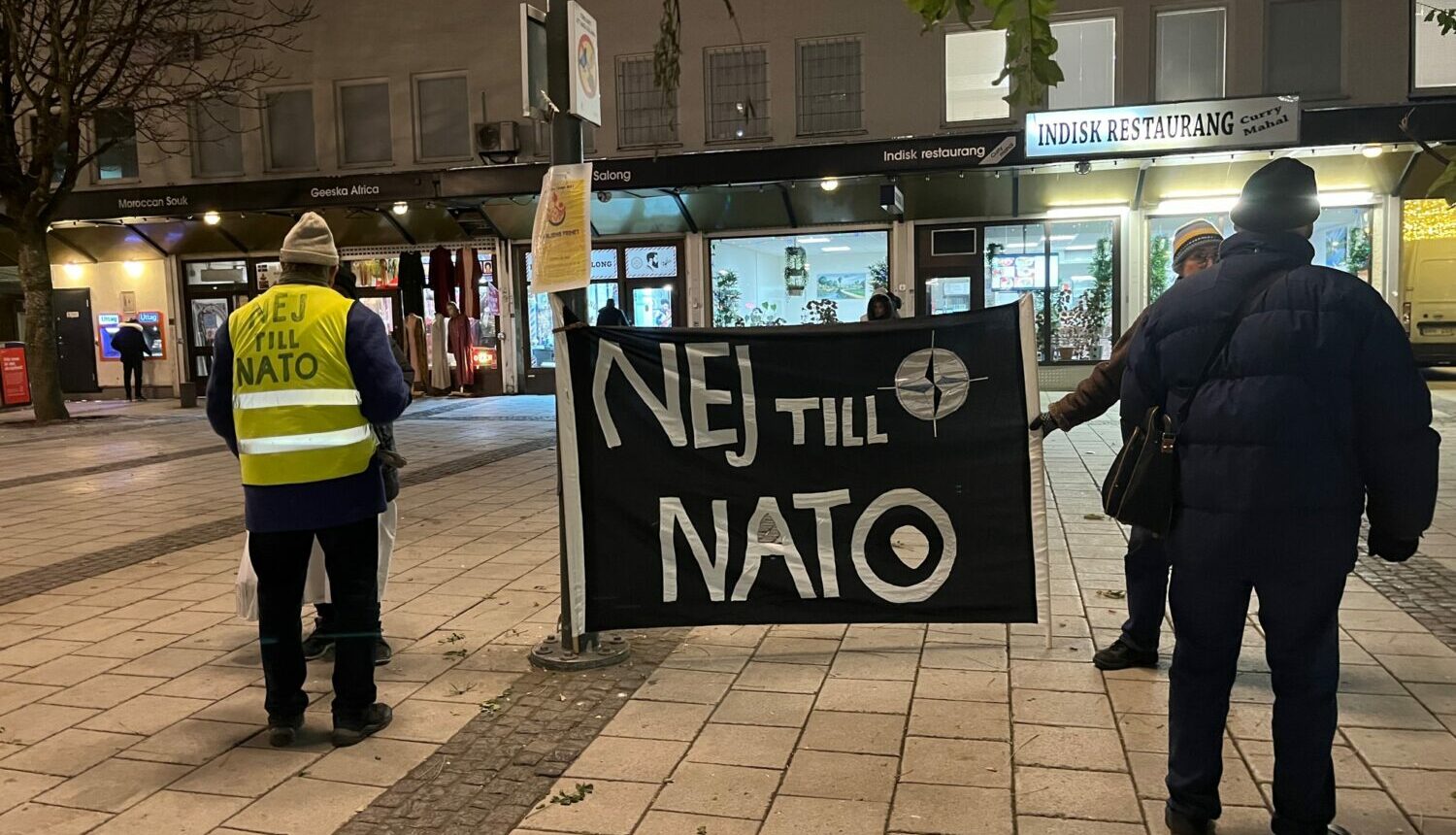 Två personer på Rinkeby torg håller i en banderoll med texten Nej till NATO.