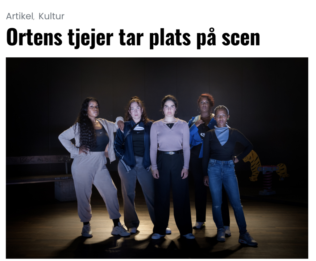 Fem orten-tjejer står på scenen.