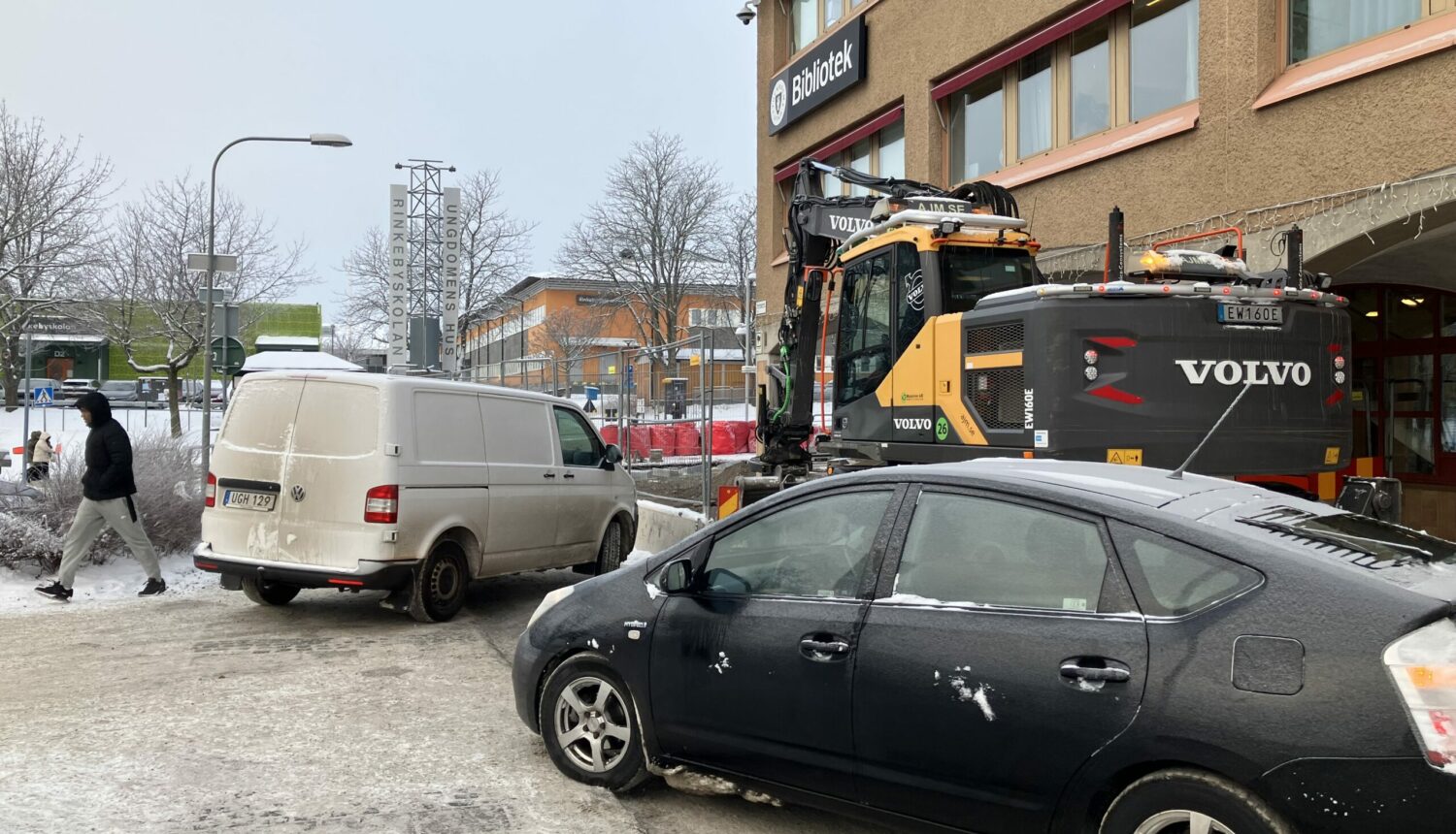 En buss och en bil trängs på en gata, som delvis är avstängd.