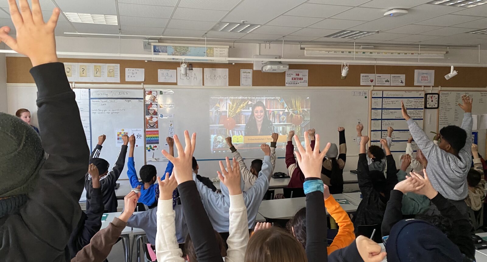 skolelever som gör vinstgest i klassrummet