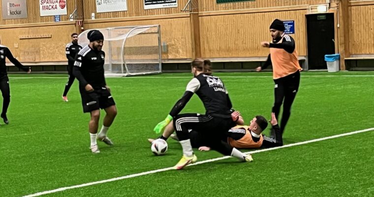 fotbollsspelare i närkamp på en konstgräsplan.