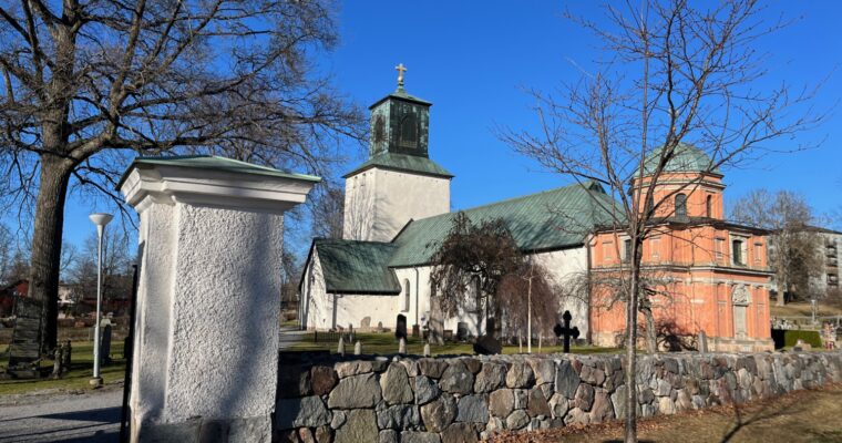 Spånga kyrka utifrån, strålande sol och knallblå himmel.