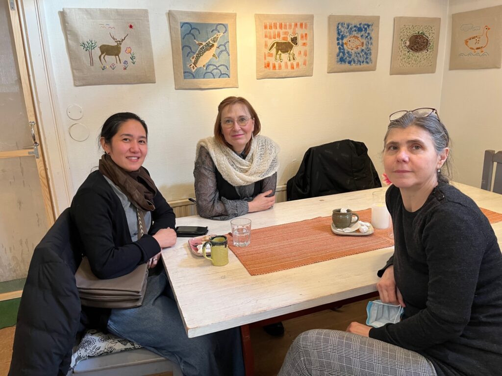 Tre kvinnor vid ett kafébord på Husby gård.