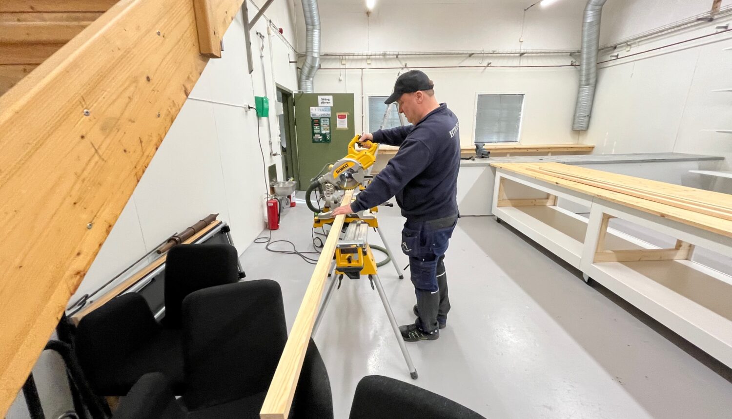 hantverkare Lars Asp sågar i en planka i fritidsbiblioteket