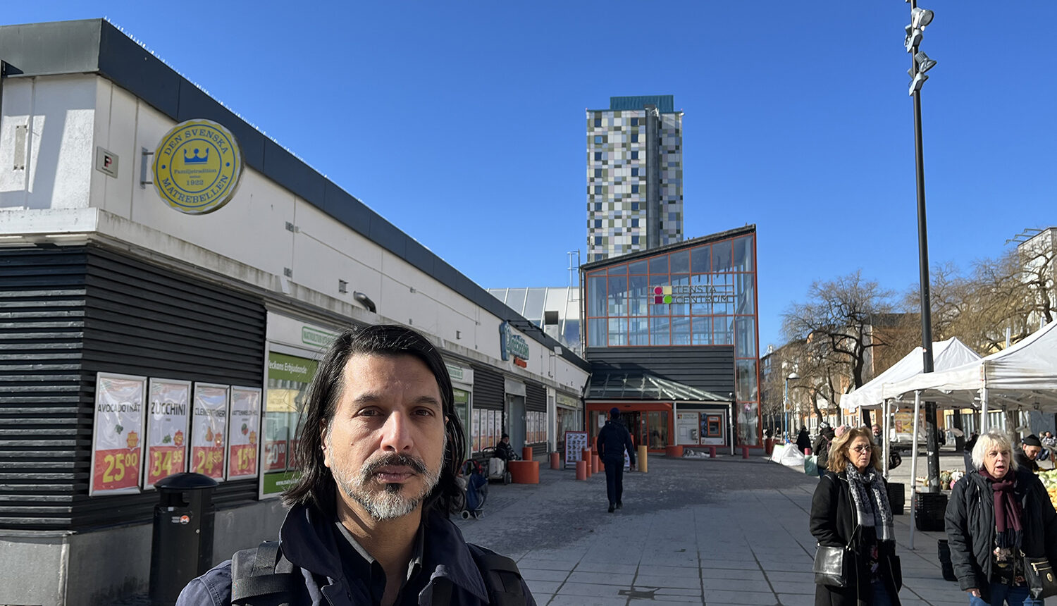 man står på gatan framför köpcentrum