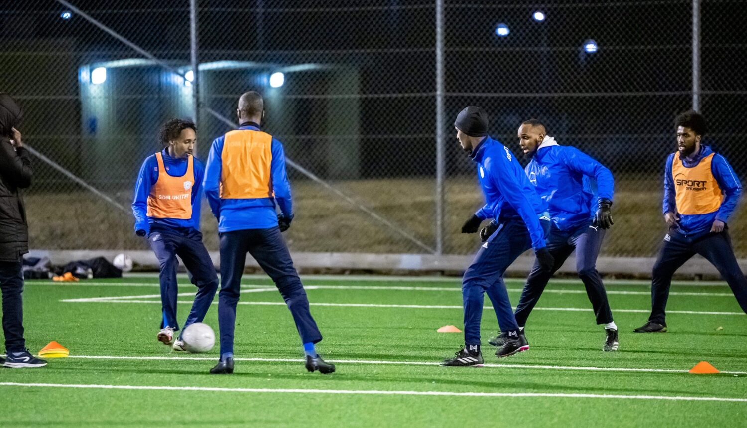 Fotbollsspelare tränar i mörkret under elbelysningen på Knutby BP.