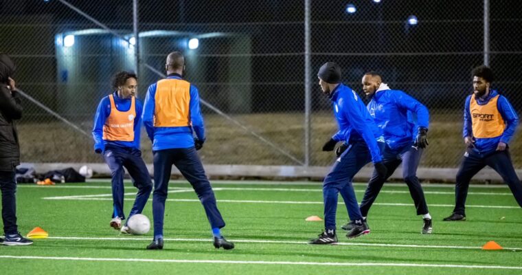 Fotbollsspelare tränar i mörkret under elbelysningen på Knutby BP.