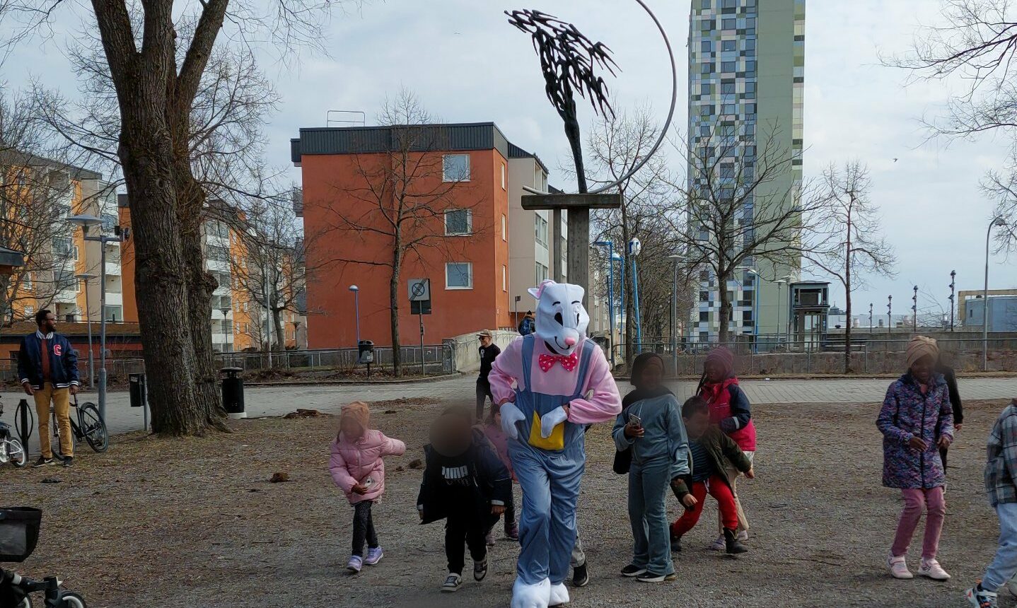 En man utklädd till hare kastar godis till barnen.