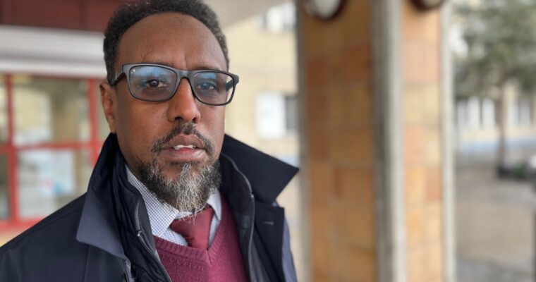 En somalisk man i 50-årsåldern, han bär solglasögon, elegant klädd.