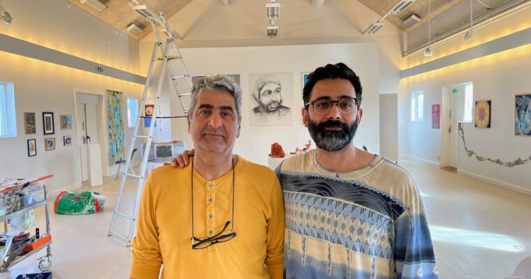 Två män som står bredvid varandra inne i konsthallen i Husby.