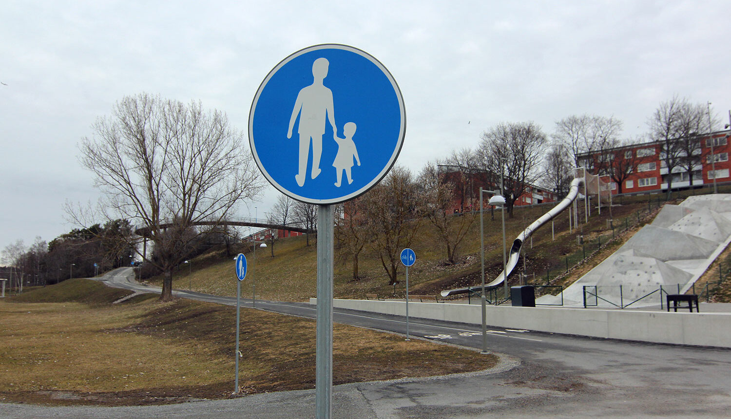 Skylt för Gångbana i Hjulsta. I bakgrunden skylt för gång- och cykelbana.
