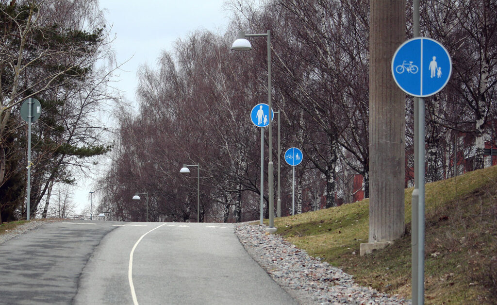 Skylt för Gångbana i Hjulsta. I bakgrunden skylt för gång- och cykelbana.