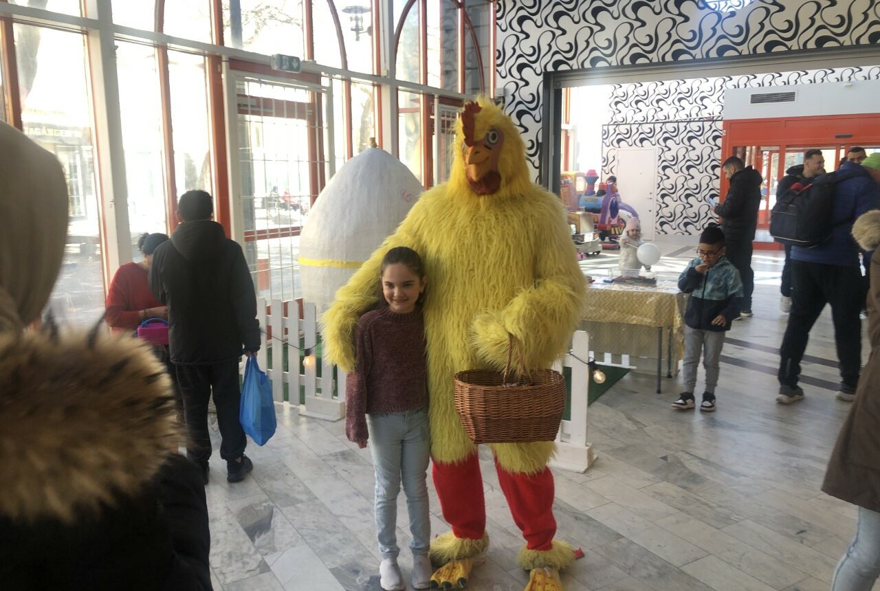 Utklädd till kyckling kramar en flicka.