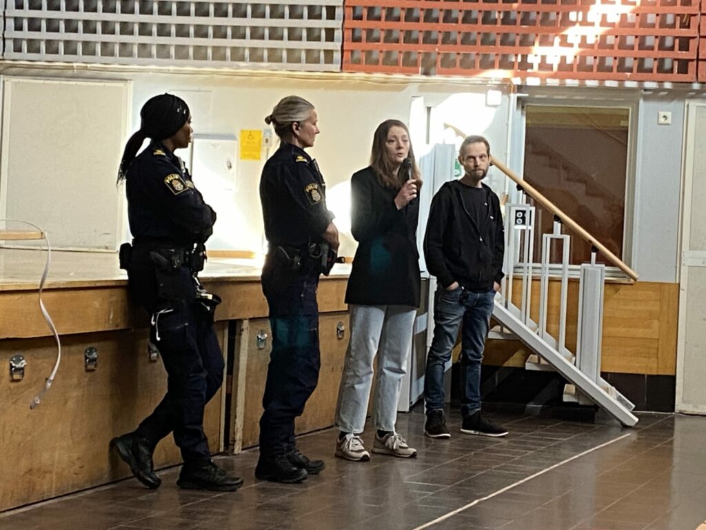 Två poliser och två civila på en scen.