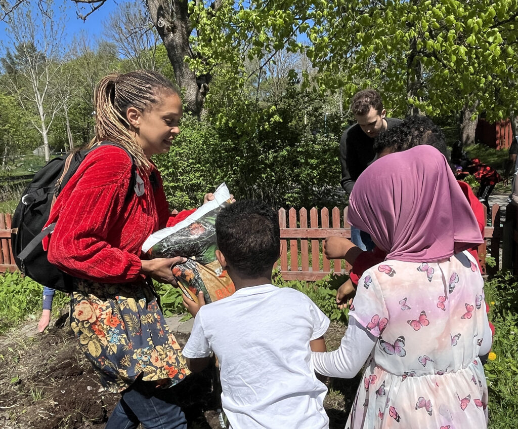 kvinna instruerar barn i odling utomhus