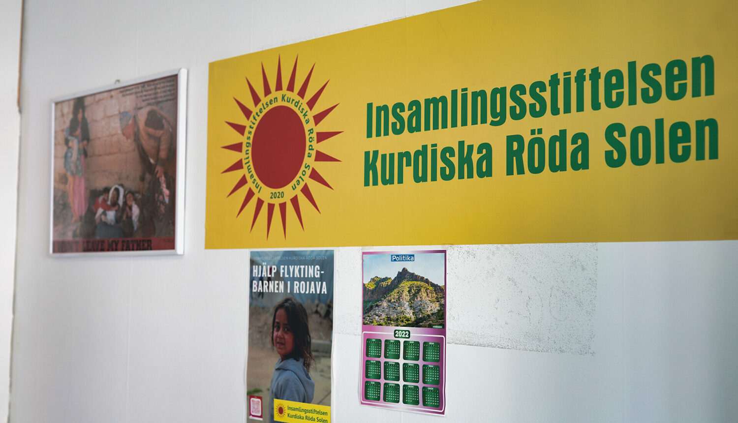 bild på gul flagga med en röd sol och texten Insamlingsstiftelsen Kurdiska Röda Solen