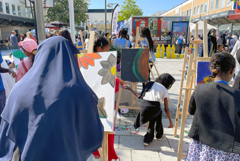 Barn målar tavlor på Rinkeby torg