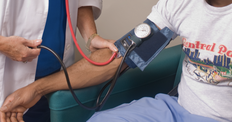 läkare som mäter blodtryck på patient