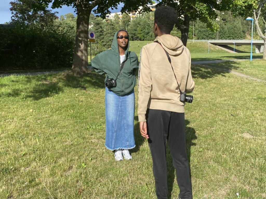 En ung kvinna talar med en ung man i en park