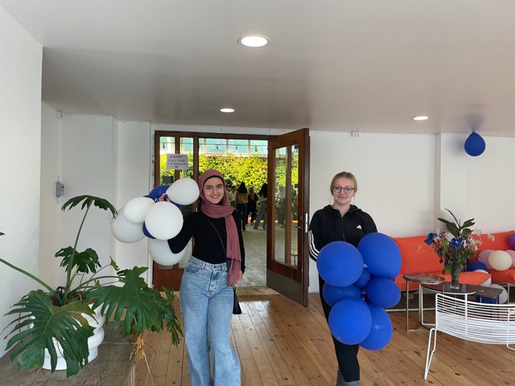 Två unga kvinnor som håller i ballonger.