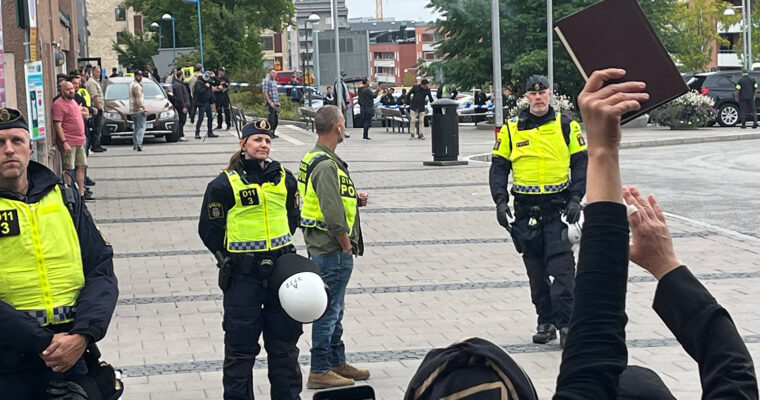 människor protesterar mot koranbränning framför poliser