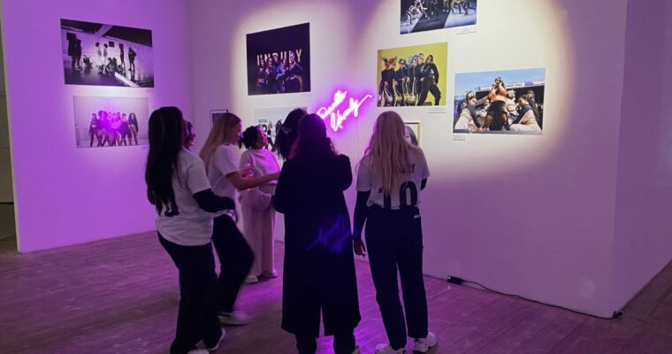 Några tjejer som står och tittar på foton på ett galleri