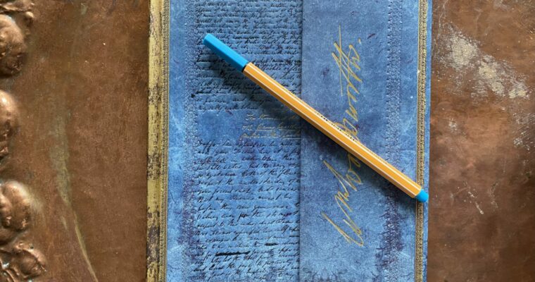 En anteckningsbok och en penna på ett bord