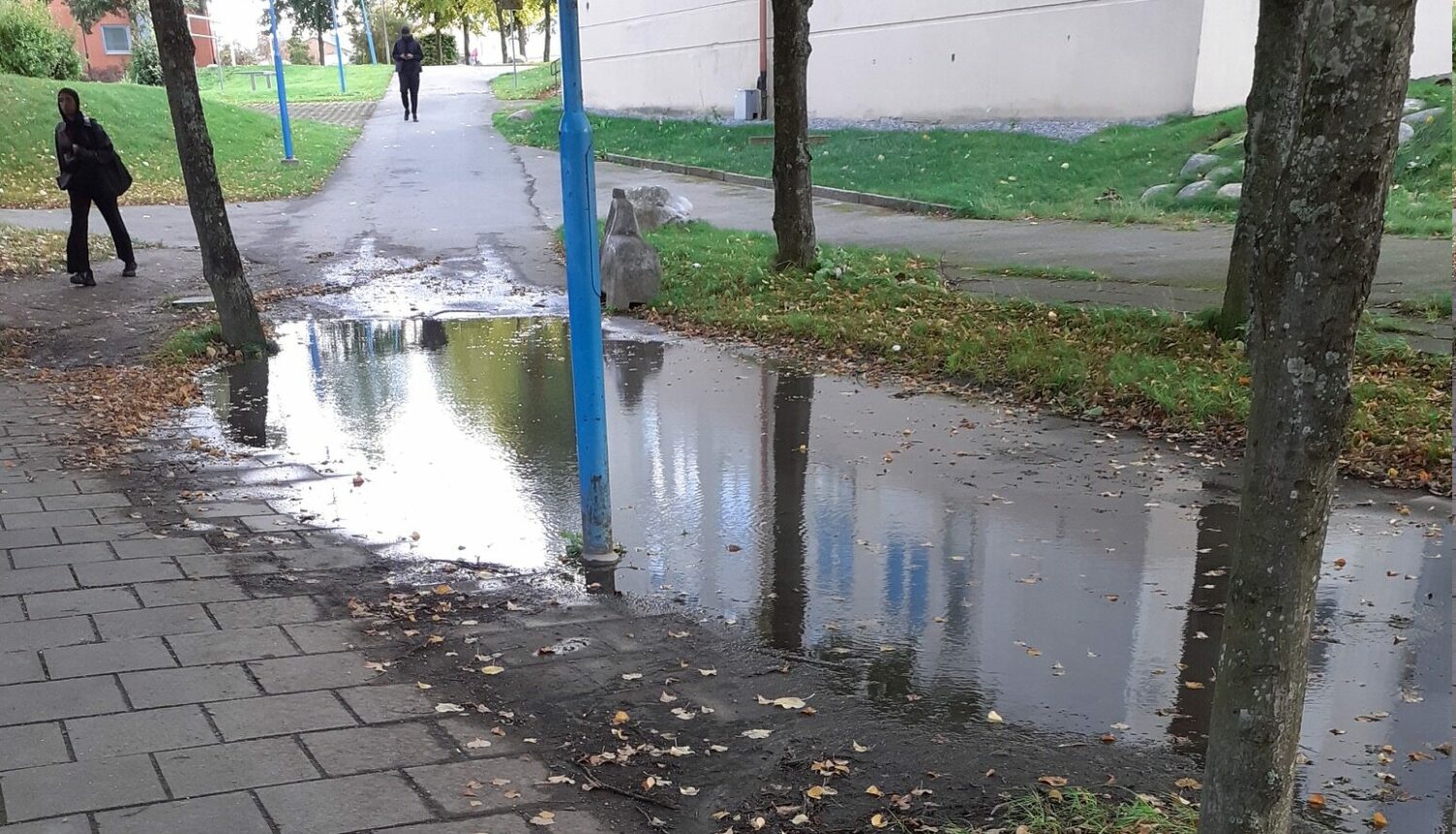 En stor vattenpöl på en trottoar.