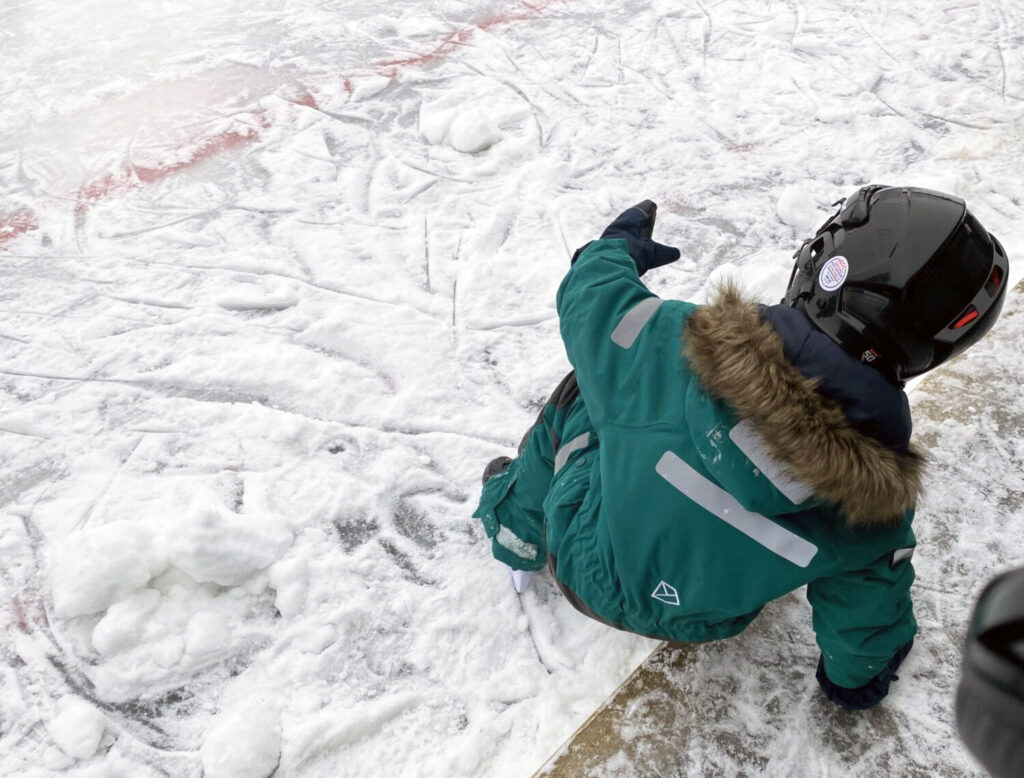 ett barn med hjälm på isen