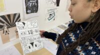 kvinna visar upp sina tecknade seriestrippar