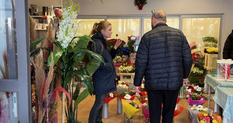 Clara Lindblom som pratar med ägaren av blomsteraffären i Tensta centrum.
