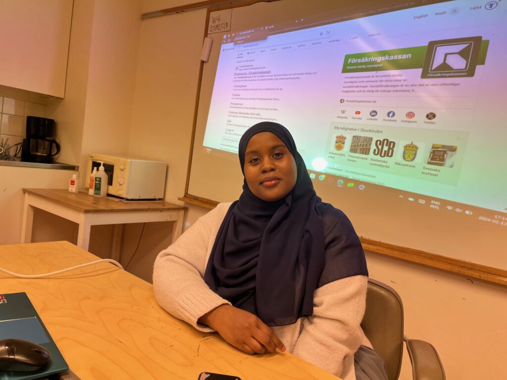En somalisk kvinna framför en dataskärm.