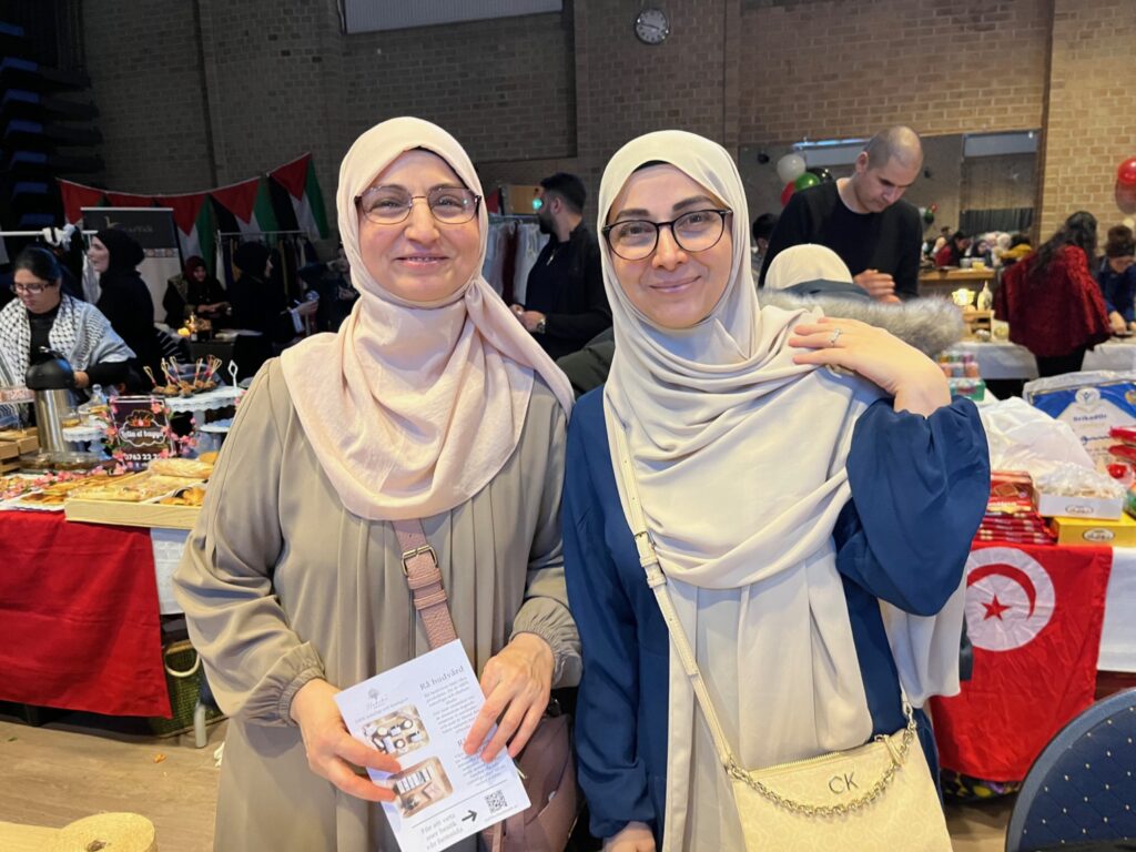 Två kvinnor i hijab säljer hudvårdsprodukter.
