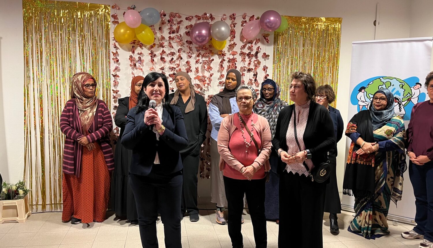Kvinnor framför glitter och ballonger på Internationella kvinnodagen.