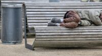 en man sover på en bänk utomhus